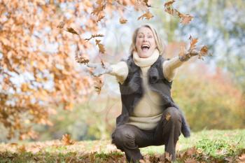 Royalty Free Photo of a Woman Throwing Leaves