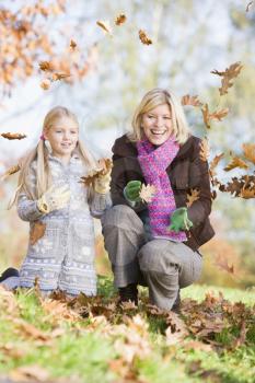 Royalty Free Photo of a Mother and Daughter Playing in the Leaves