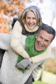 Royalty Free Photo of a Man Giving a Woman a Piggyback Ride