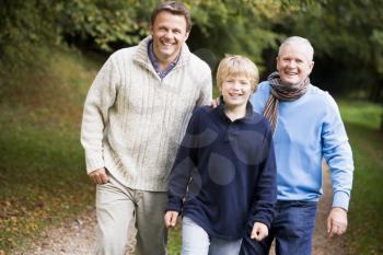 Royalty Free Photo of Two Men and a Young Boy Walking on a Trail