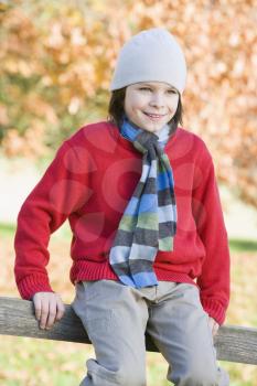 Royalty Free Photo of a Boy Sitting on a Fence
