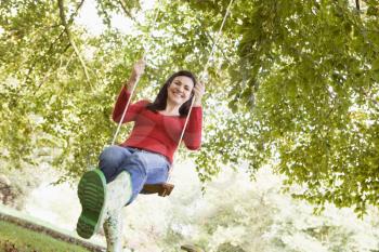 Royalty Free Photo of a Woman on a Tree Swing