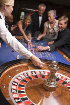 Royalty Free Photo of a People Around a Roulette Wheel