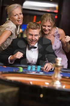 Royalty Free Photo of a Man and Two Women at a Roulette Table