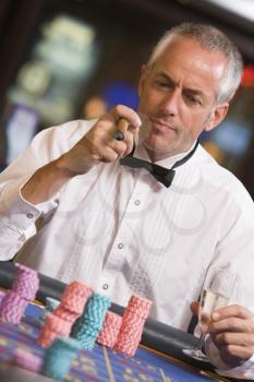 Royalty Free Photo of a Man at a Roulette Table With a Cigar