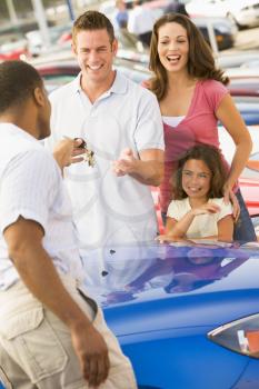 Royalty Free Photo of a Young Family Shopping for a Car