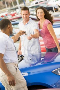 Royalty Free Photo of a Young Couple Shopping for a Car