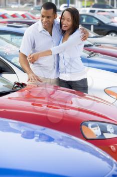 Royalty Free Photo of a Couple Looking at Cars