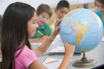 Royalty Free Photo of a Student Pointing at a Globe