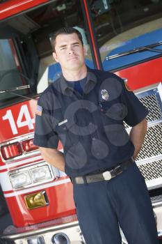 Royalty Free Photo of a Firefighter Standing in Front of a Firetruck
