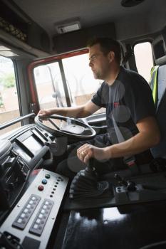 Royalty Free Photo of a Firefighter Driving the Truck