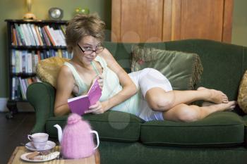 Royalty Free Photo of a Woman on the Sofa Writing in a Diary