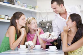 Royalty Free Photo of a Man Showing Women the Dessert Tray