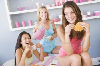 Royalty Free Photo of Three Young Women Having Tea and Pastries