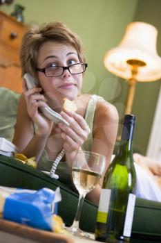 Royalty Free Photo of a Young Woman Talking on a Phone and Drinking Wine