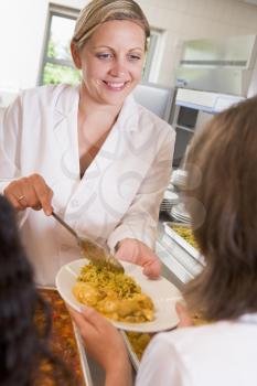 Royalty Free Photo of a Lunch Woman Serving a Student