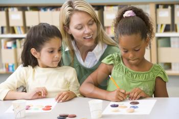 Royalty Free Photo of Two Girls With a Teacher in Art Class