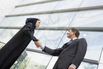 Royalty Free Photo of a Western Man and Eastern Woman Shaking Hands