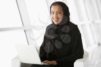 Royalty Free Photo of a Woman Sitting Indoors With a Laptop