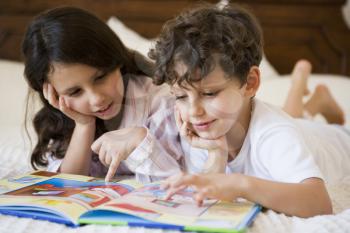 Royalty Free Photo of Two Children Reading at Bedtime