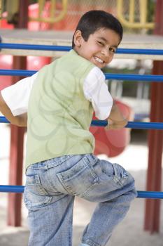 Royalty Free Photo of a Young Boy on Playground Equipment