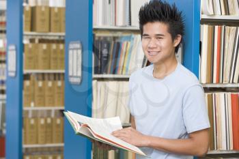 Royalty Free Photo of a Guy in a Library With a Book