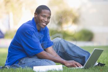 Royalty Free Photo of a Boy on the Lawn With a Laptop