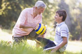 Royalty Free Photo of a Grandson and Grandfather With a Ball