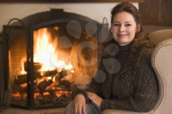 Royalty Free Photo of a Woman By a Fireplace