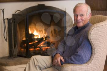 Royalty Free Photo of a Man Beside a Fireplace