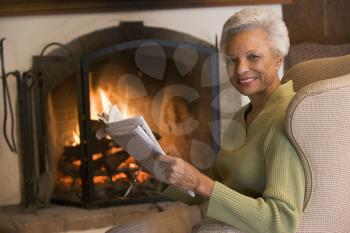 Royalty Free Photo of a Woman Reading Beside a Fireplace