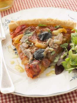 Royalty Free Photo of a Slice of Provencale Tart with Dressed salad