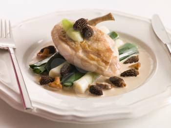 Royalty Free Photo of a Breast of Chicken with Morels Baby Leeks and Madeira Cream