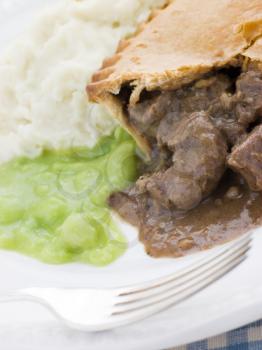 Royalty Free Photo of Steak Pie and Mash with Mushy Peas