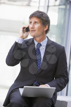 Royalty Free Photo of a Man Talking on the Phone With a Laptop