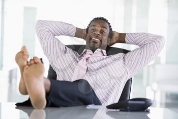 Royalty Free Photo of a Man at a Desk With his Feet Up