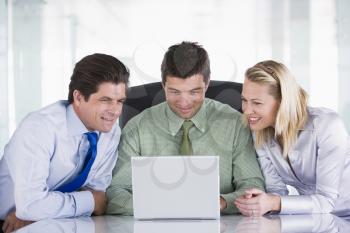 Royalty Free Photo of Three People Around a Laptop