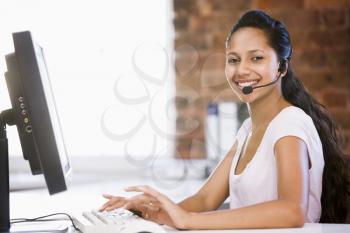 Royalty Free Photo of a Woman at a Computer Wearing a Headset