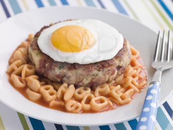 Royalty Free Photo of Corned Beef Hash Cake With Alphabet Pasta and a Fried Egg