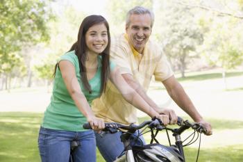 Royalty Free Photo of a Man and Girl on Bikes