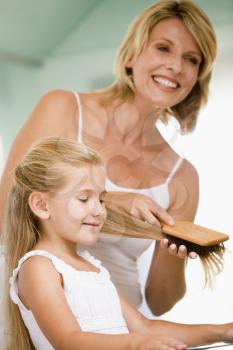 Royalty Free Photo of a Woman Brushing Her Daughter's Hair