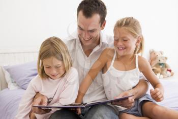 Royalty Free Photo of a Father Reading to His Daughters