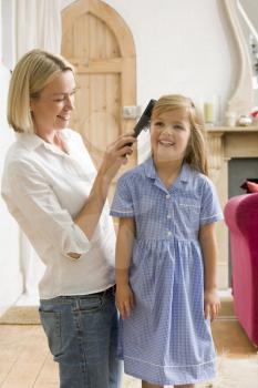 Royalty Free Photo of a Woman Brushing a Girl's Hair