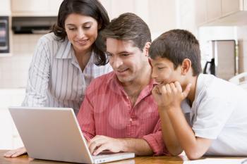 Royalty Free Photo of a Family in a Kitchen With a Laptop