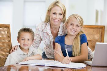 Royalty Free Photo of a Mother Helping Her Two Children With Homework