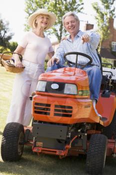 Royalty Free Photo of a Couple With a Riding Lawn Mower