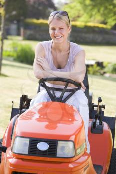Royalty Free Photo of a Woman on a Riding Lawn Mower
