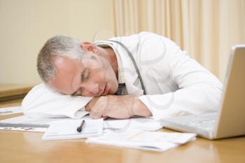 Royalty Free Photo of a Doctor Sleeping on His Desk