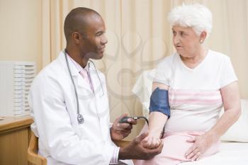 Royalty Free Photo of a Doctor Checking a Woman's Blood Pressure