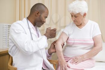 Royalty Free Photo of a Doctor Giving a Woman a Needle